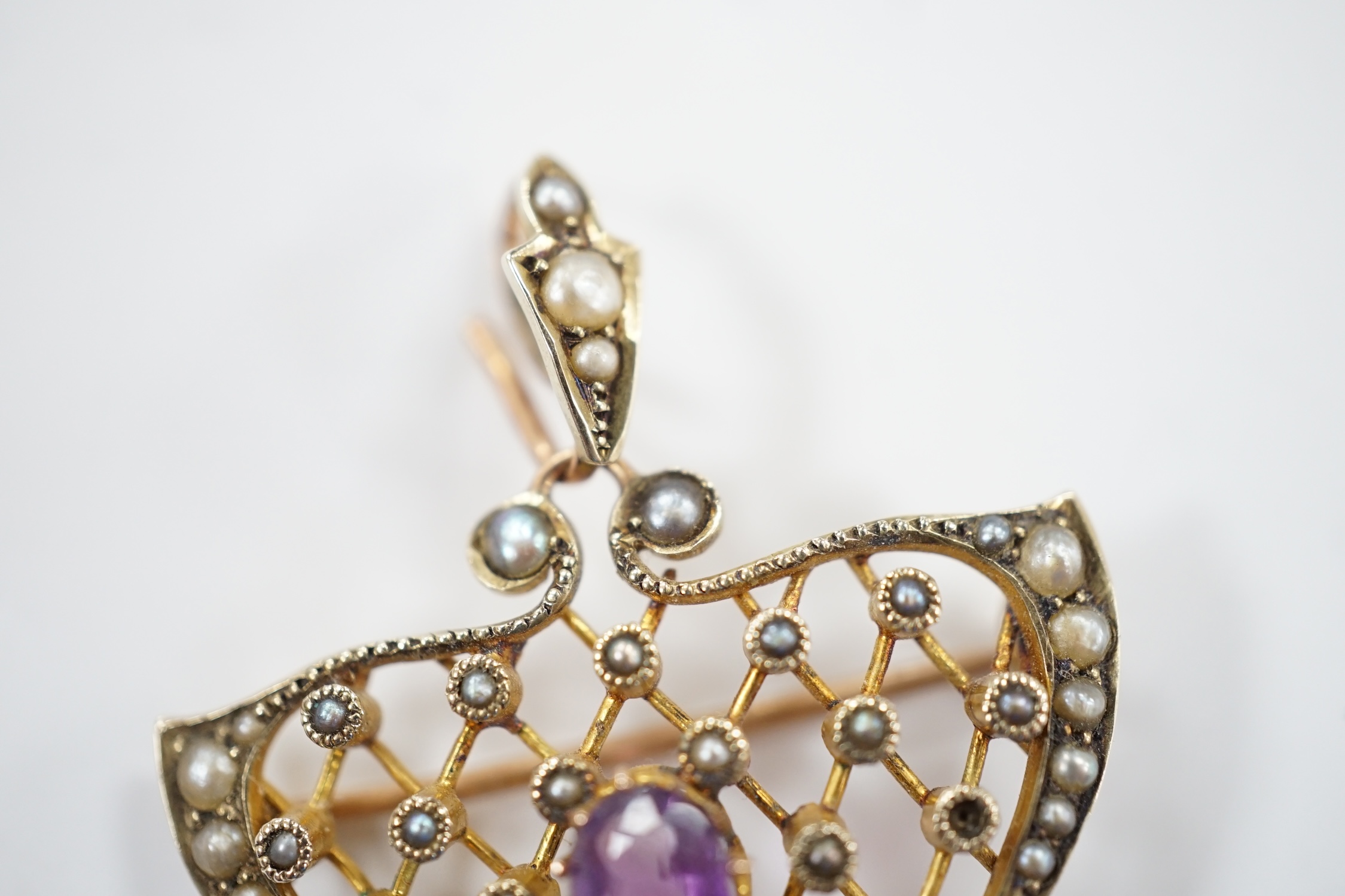 An Edwardian Art Nouveau 9ct, amethyst and seed pearl set drop pendant, 50mm, gross weight 5.2 grams.